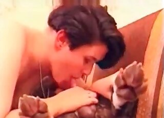 Short-haired brunette performs a passionate blowjob to her dog