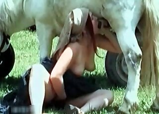 Busty slut gladly sucks white horse's thick cock in open air