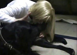 Stockings-wearing blonde zoophile jerking a black dog's dick hard