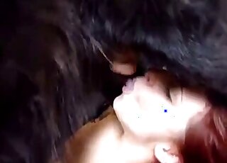 Naughty redhead loves sucking off her black dog before sex